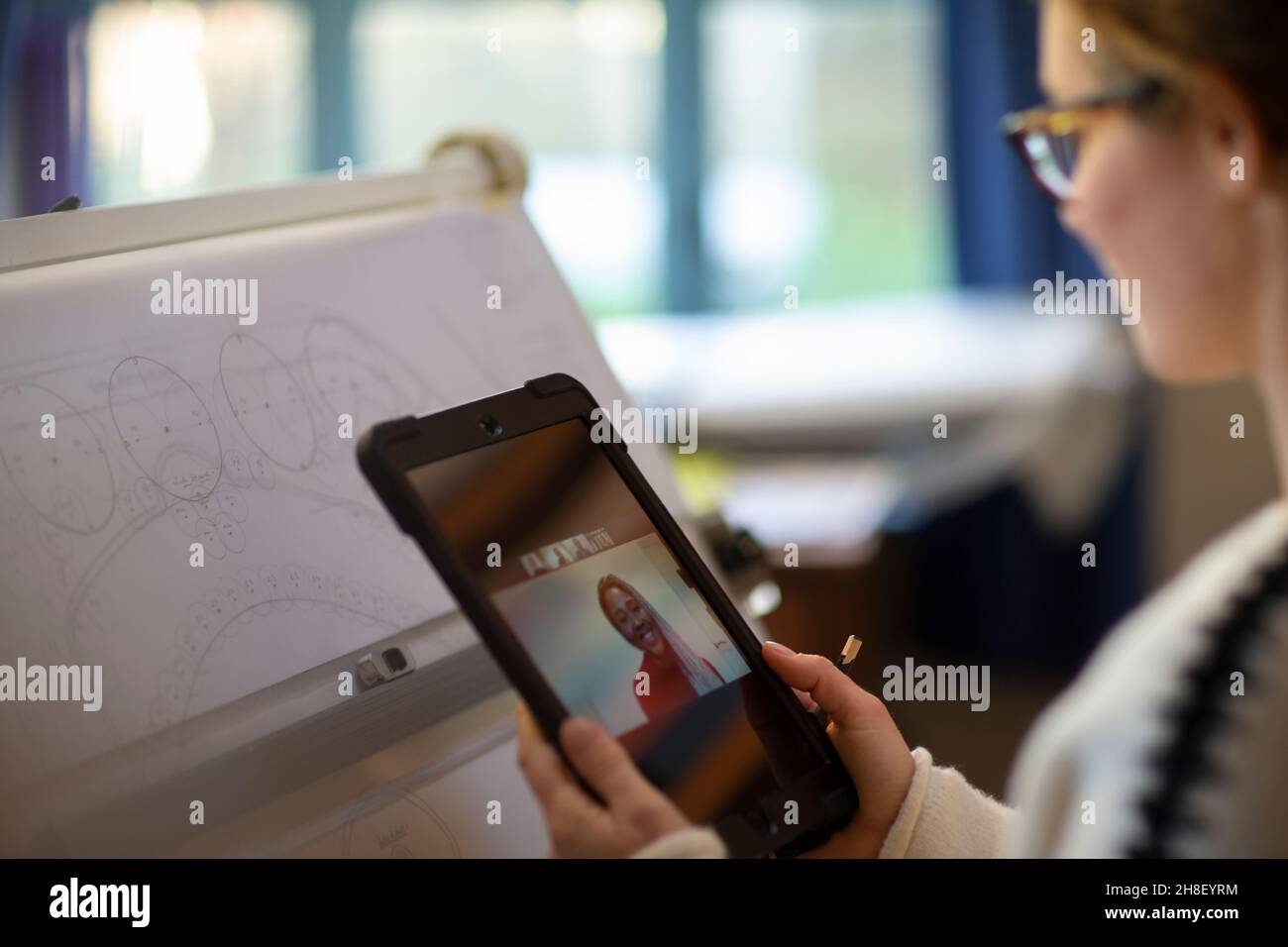 Vídeo de arquitecto femenino charlando con su compañero en una tableta digital Foto de stock