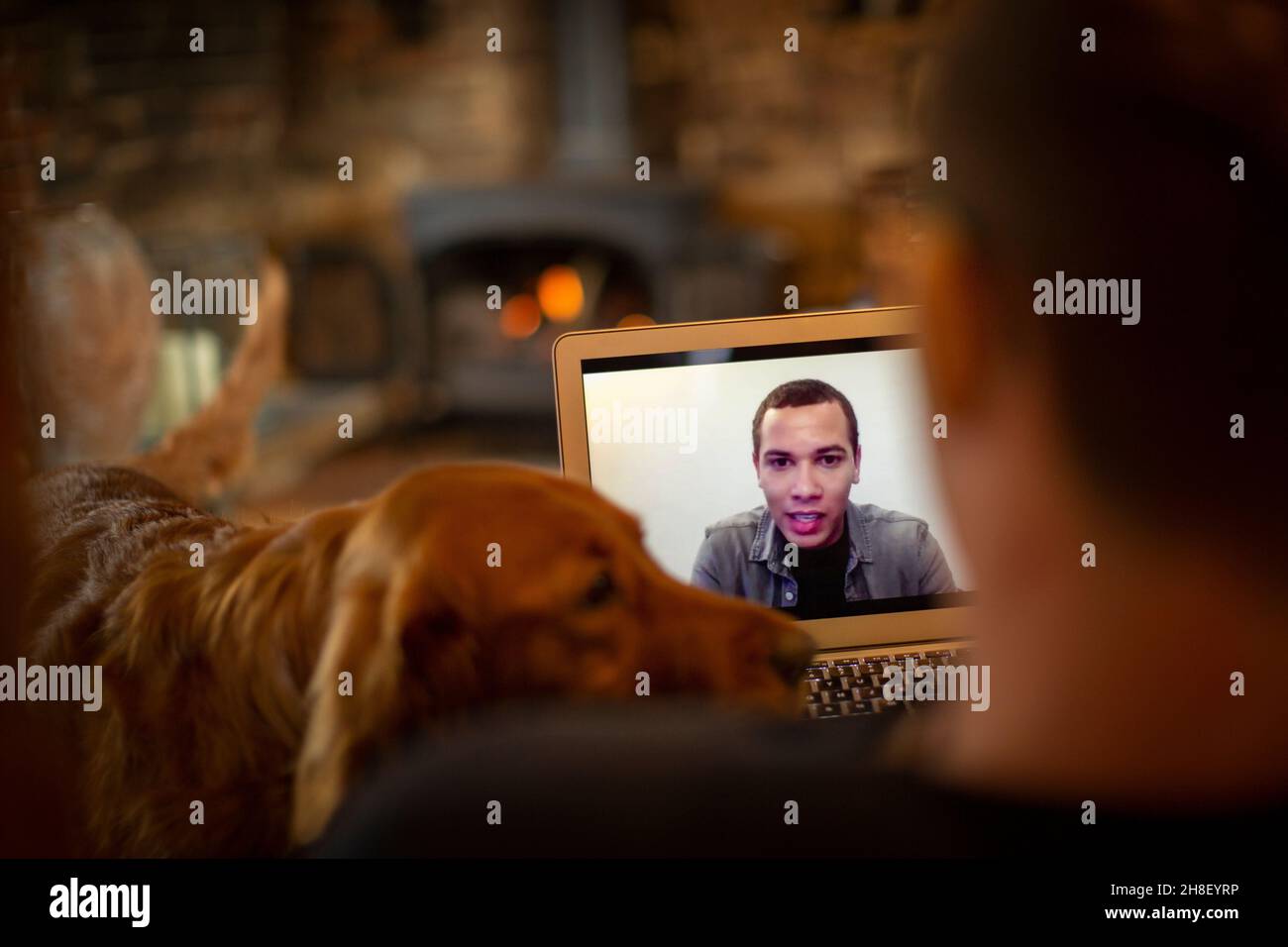 Hombre con perro de vídeo charlando con su compañero en la pantalla del portátil Foto de stock