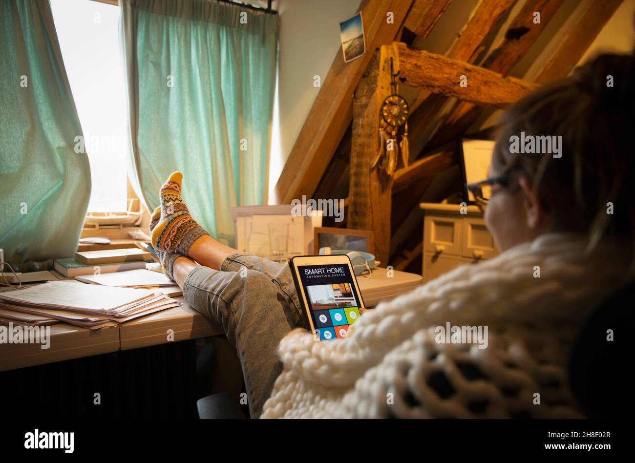 Mujer mirando la automatización doméstica en la pantalla digital de la tableta Foto de stock