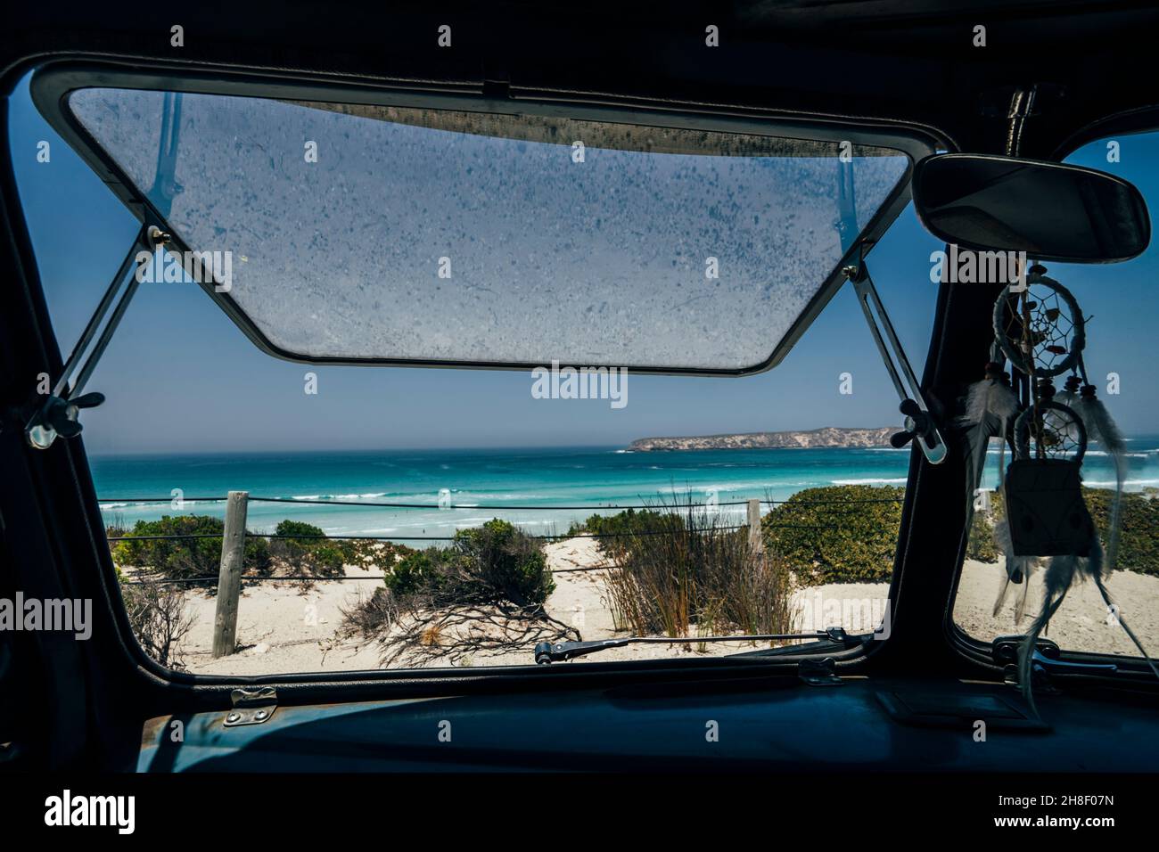 Ventana de autobús abierta al soleado paisaje idílico del mar Foto de stock