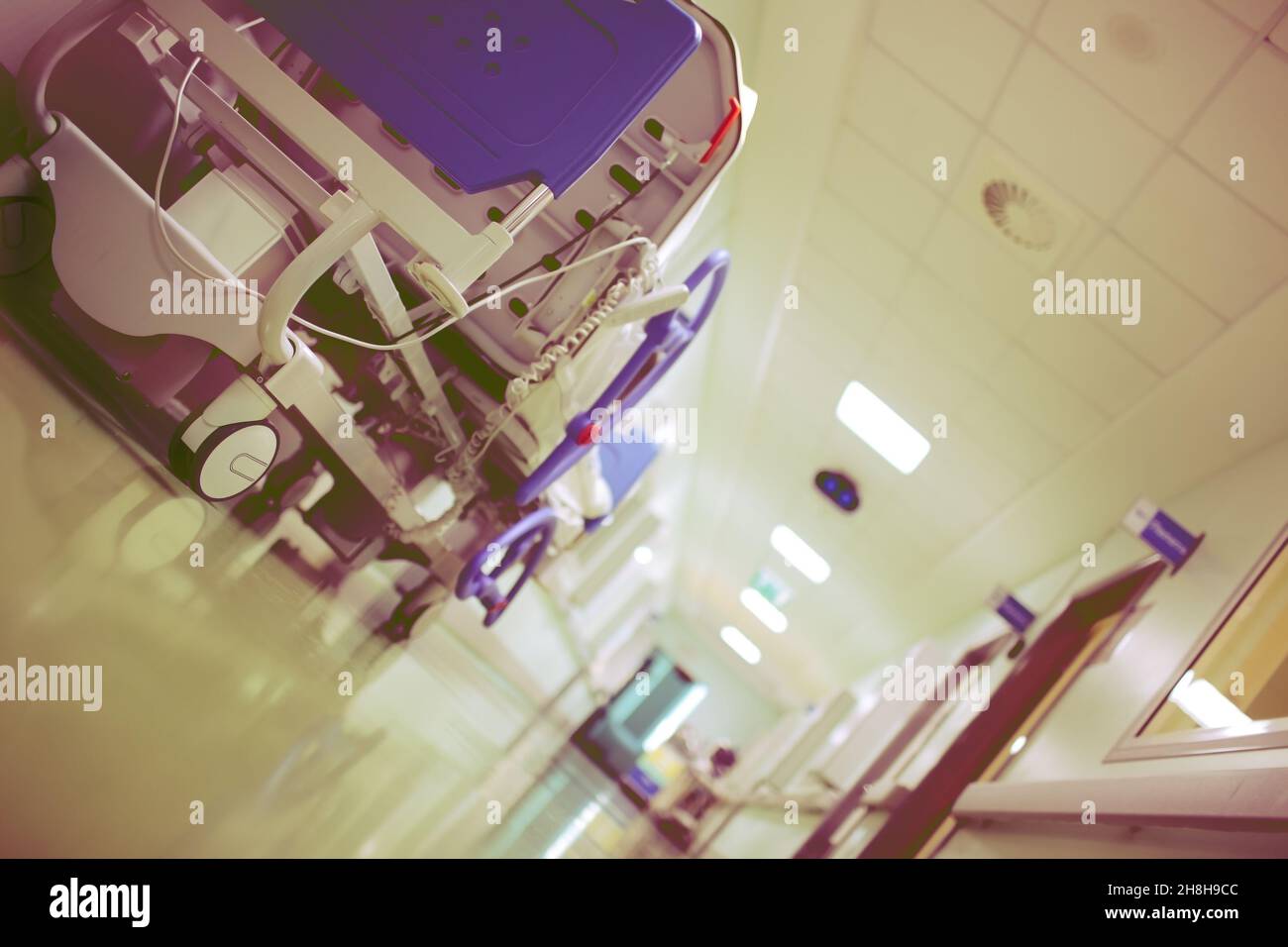 Cama de ruedas avanzada en el vestíbulo del hospital con un ángulo de visión inusual. Foto de stock
