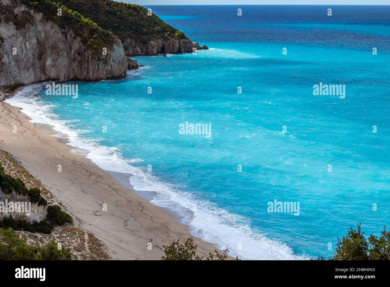 Vista aérea en la playa de arena de Mylos con olas tormentosas y azules en la costa de la isla Lefkada en Grecia. Vacaciones de verano naturaleza viaje al mar Jónico Foto de stock