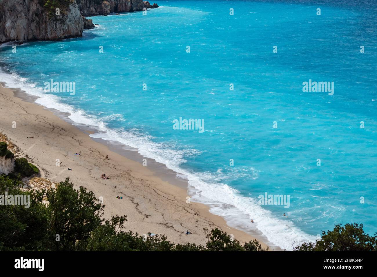 Vista cercana de la playa de arena de Mylos con olas vibrantes en la costa de la isla Lefkada en Grecia. Vacaciones de verano naturaleza viaje al mar Jónico Foto de stock