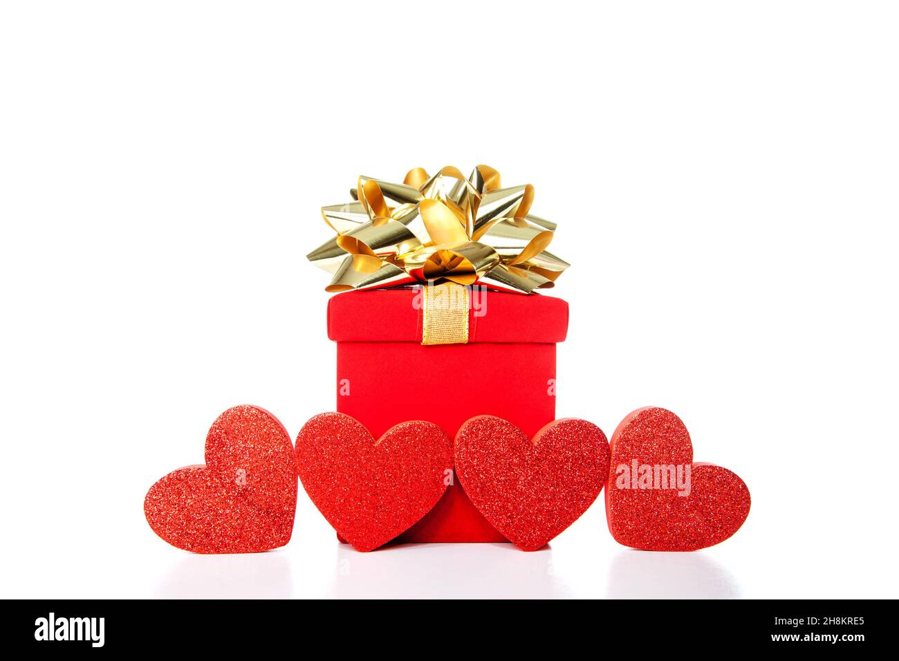 Caja de regalo roja con lazo dorado y 4 corazones aislados sobre fondo  blanco. Concepto de celebraciones como Navidad, Boda, Día de San Valentín,  u otro happ Fotografía de stock - Alamy