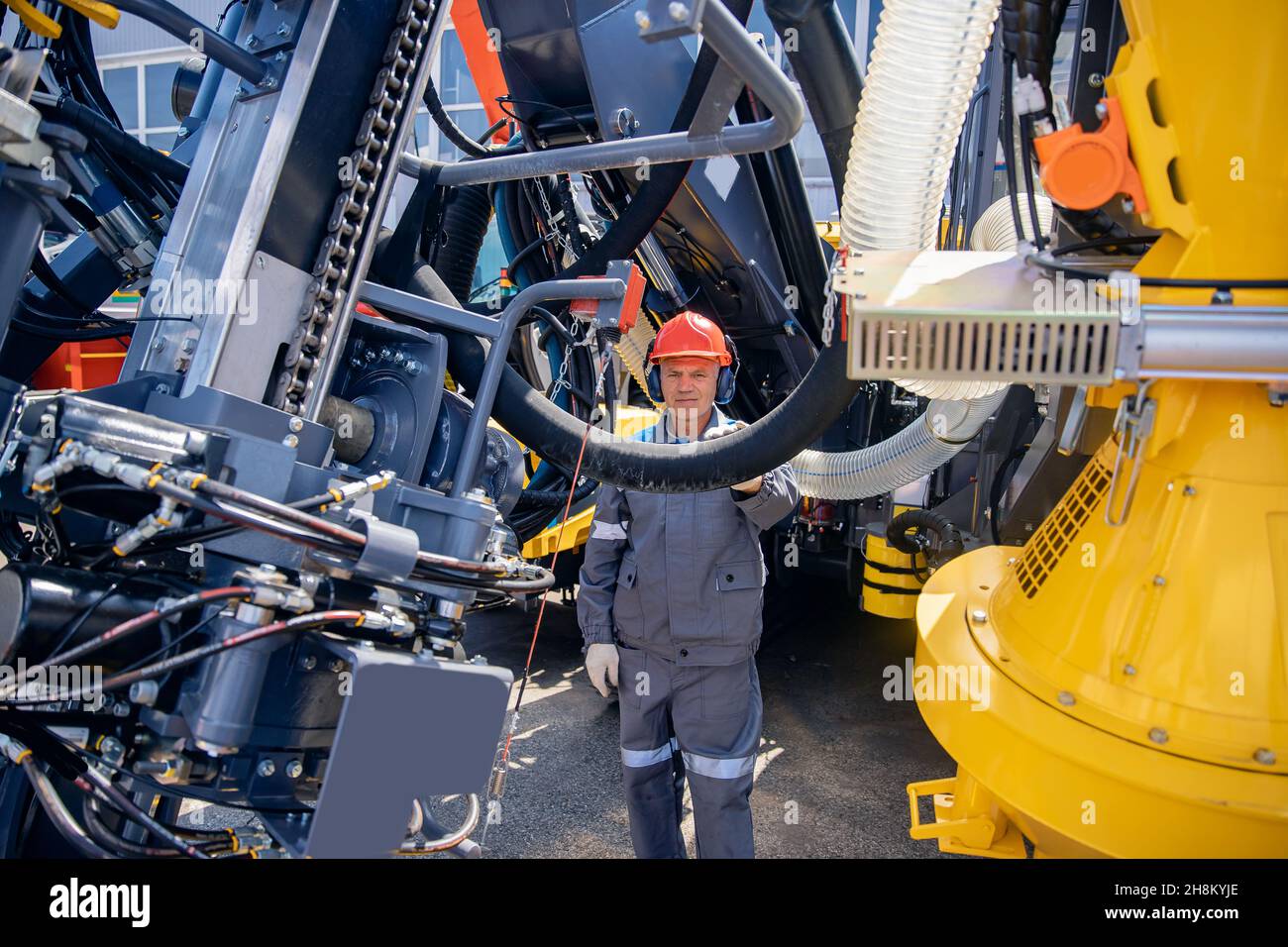 Ingeniero en casco y uniforme está dando servicio a los sistemas hidráulicos  de equipos mineros para descender a la mina Fotografía de stock - Alamy