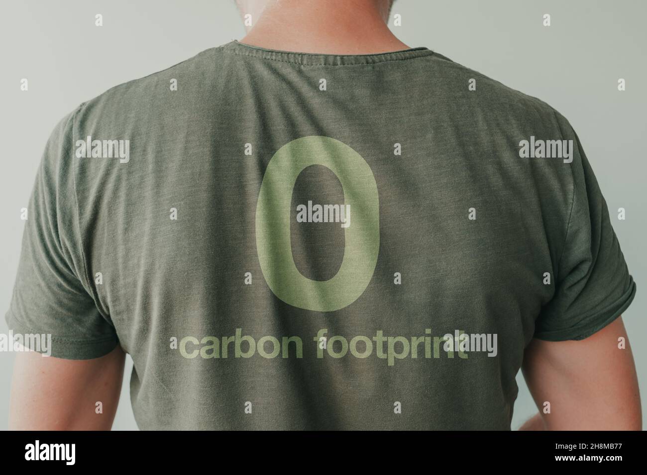 Hombre con camiseta verde con 0 letras de carbono en la espalda, retrato de ambientalista y activista medioambiental Foto de stock