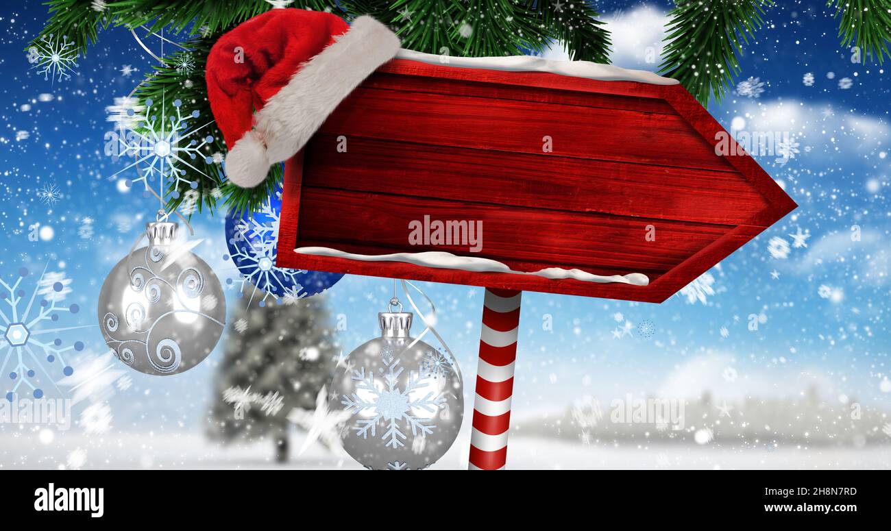 Imagen compuesta digital de Santa Hat en pizarra de señalización de dirección roja en blanco con espacio de copia durante el invierno Foto de stock