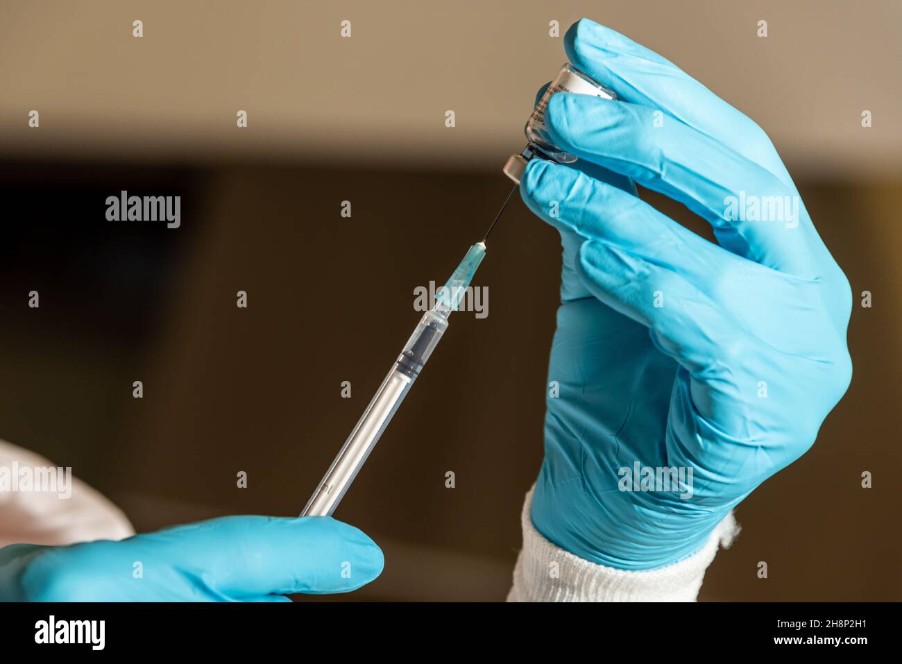 Aufziehen einer Impffosis in eine Impfspritze zur Vorbereitung auf den Impfvorgang Foto de stock