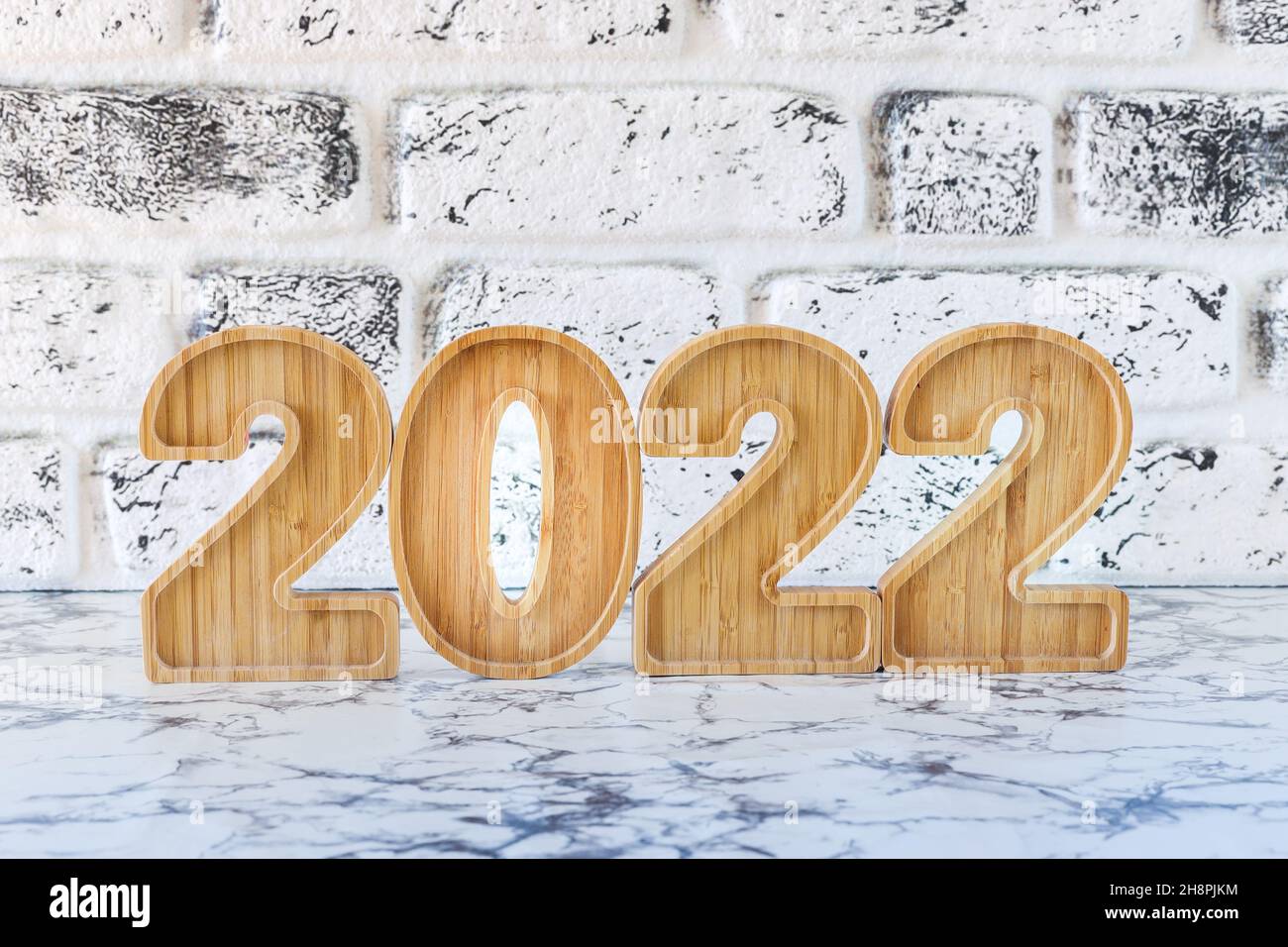 año nuevo 2022 con formas de números de madera sobre fondo blanco en forma de pared. Feliz año nuevo, Copy Space. Foto de stock