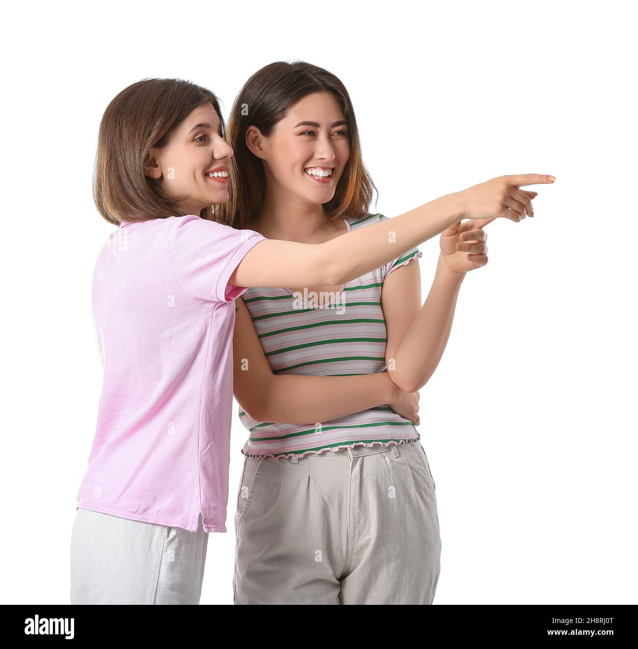 Mujeres jóvenes chismeantes sobre fondo blanco Foto de stock