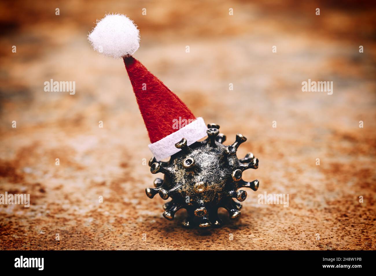 El virus de la corona lleva puesto un sombrero de Santa Claus Foto de stock
