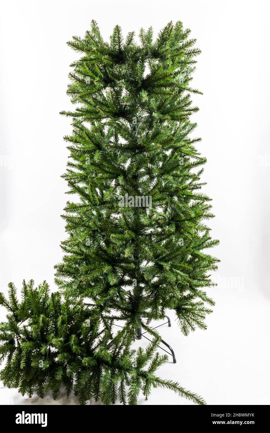Árbol de Navidad artificial que se monta sobre un fondo blanco Foto de stock