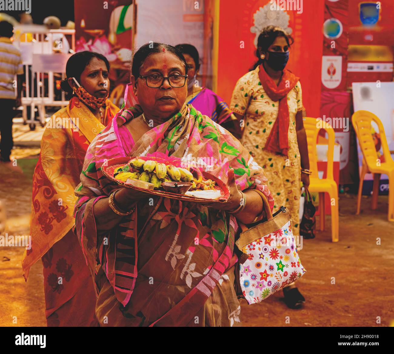 Mujer devota, mudarse a Durga Puja, pandal, ofrendas, en su, mano, para, puja, a la Diosa, Calcuta, India Foto de stock