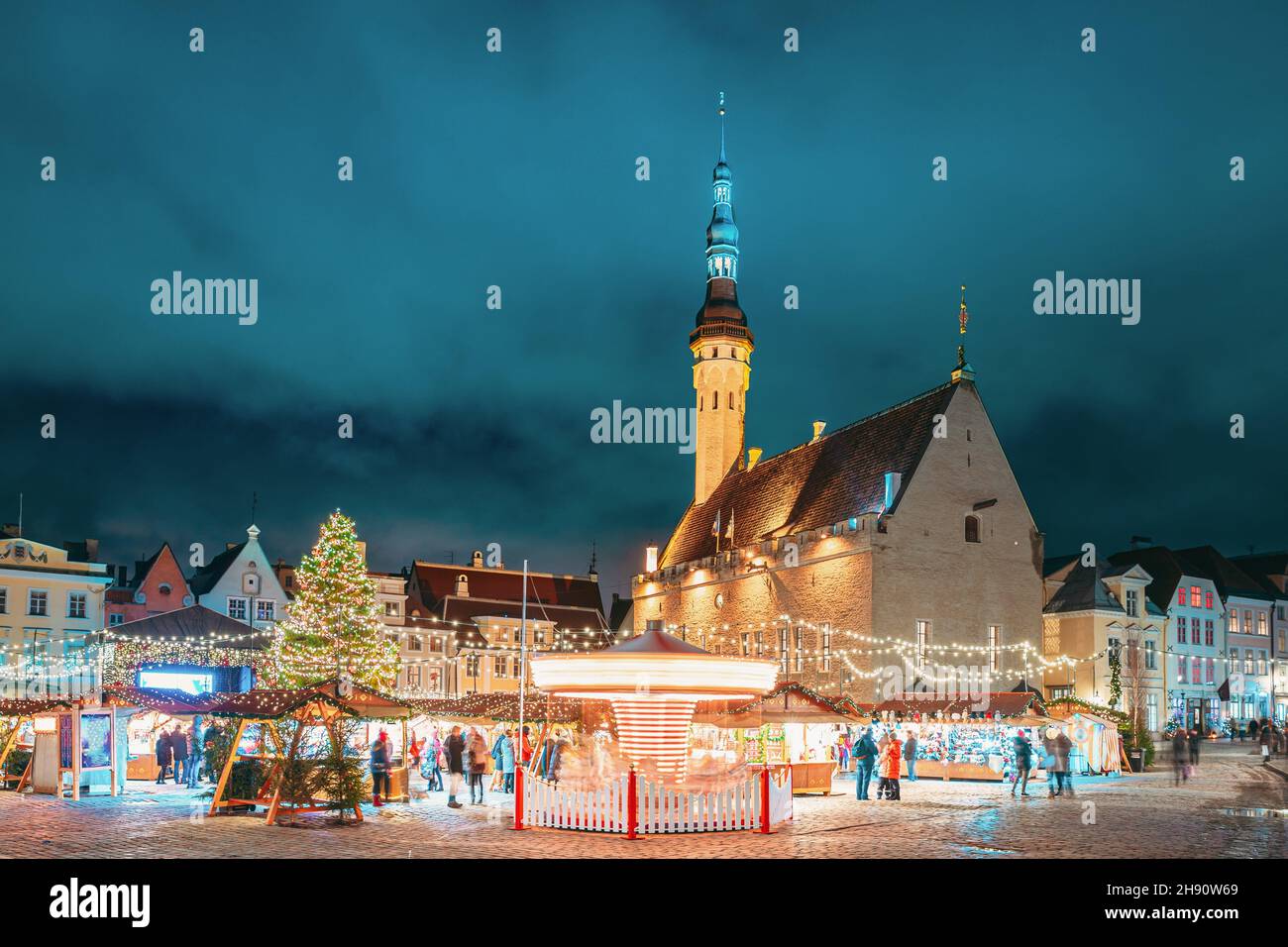 Tallin, Estonia. Mercado de Navidad tradicional y carrusel en la Plaza del Ayuntamiento. Árbol de Navidad y casas comerciales con venta de regalos de Navidad, Foto de stock
