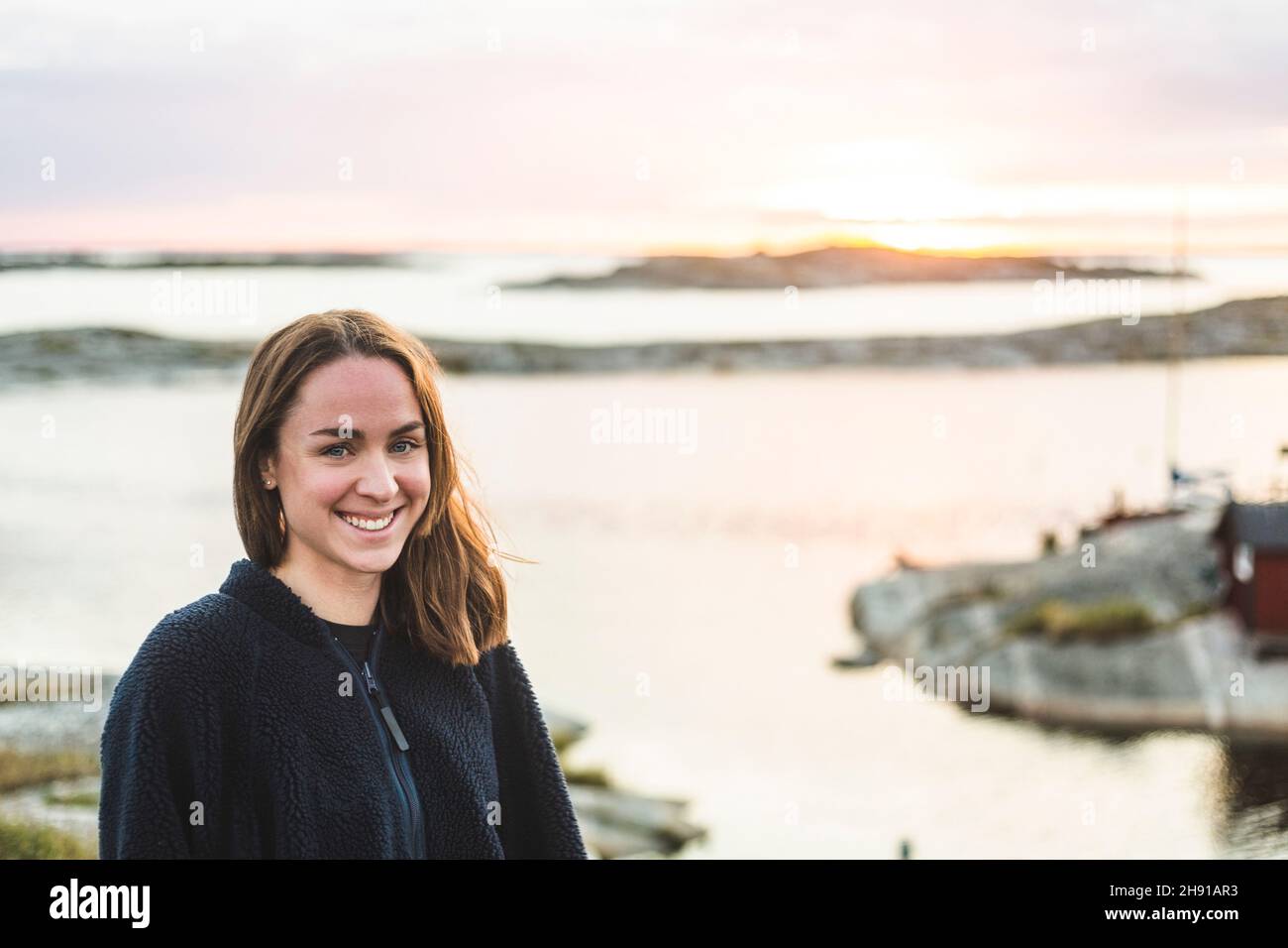 Retrato de una mujer sonriente contra el mar durante las vacaciones Foto de stock