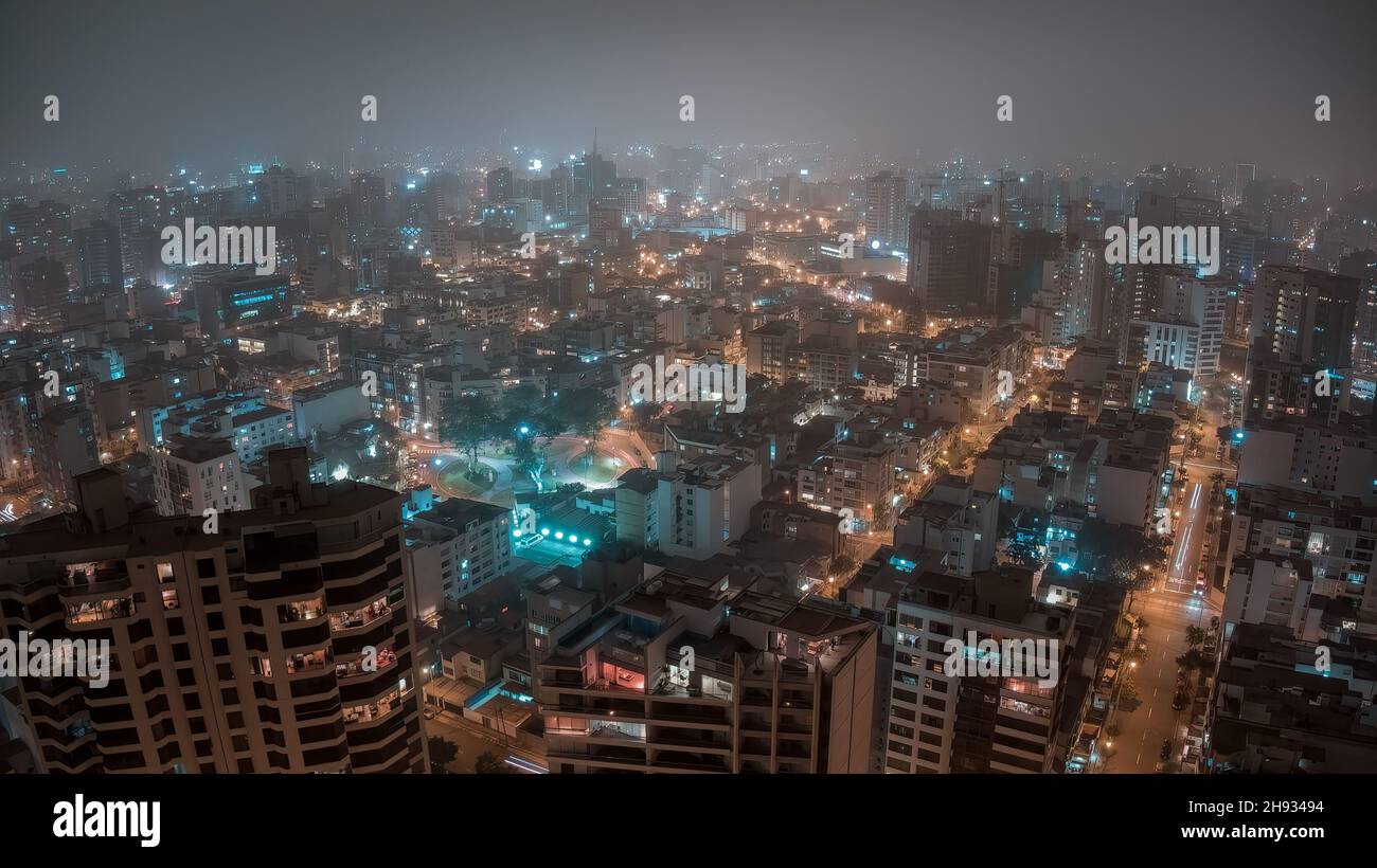 Vista nocturna aérea panorámica sobre Ovalo Bolognesi en el distrito de Miraflores desde Lima, Perú Foto de stock