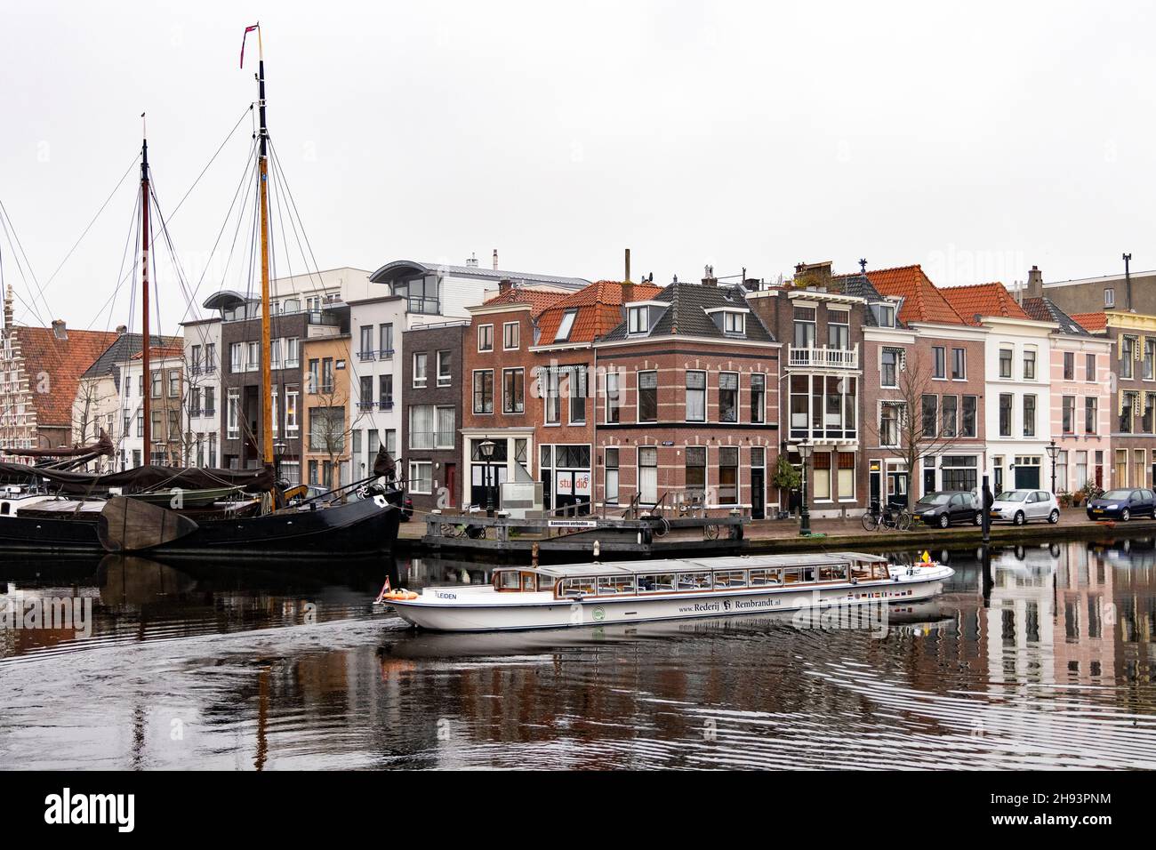 Un barco turístico pasa por los edificios históricos de Kort Galgewater en el río Rin en Leiden, Holanda. Foto de stock