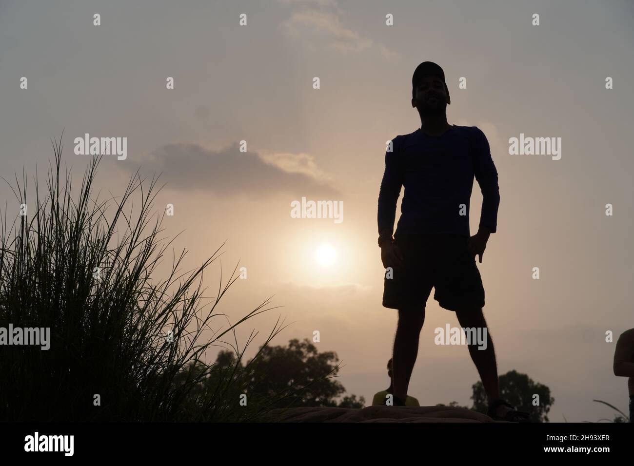 hombre por la noche cerca del sol de pie Foto de stock