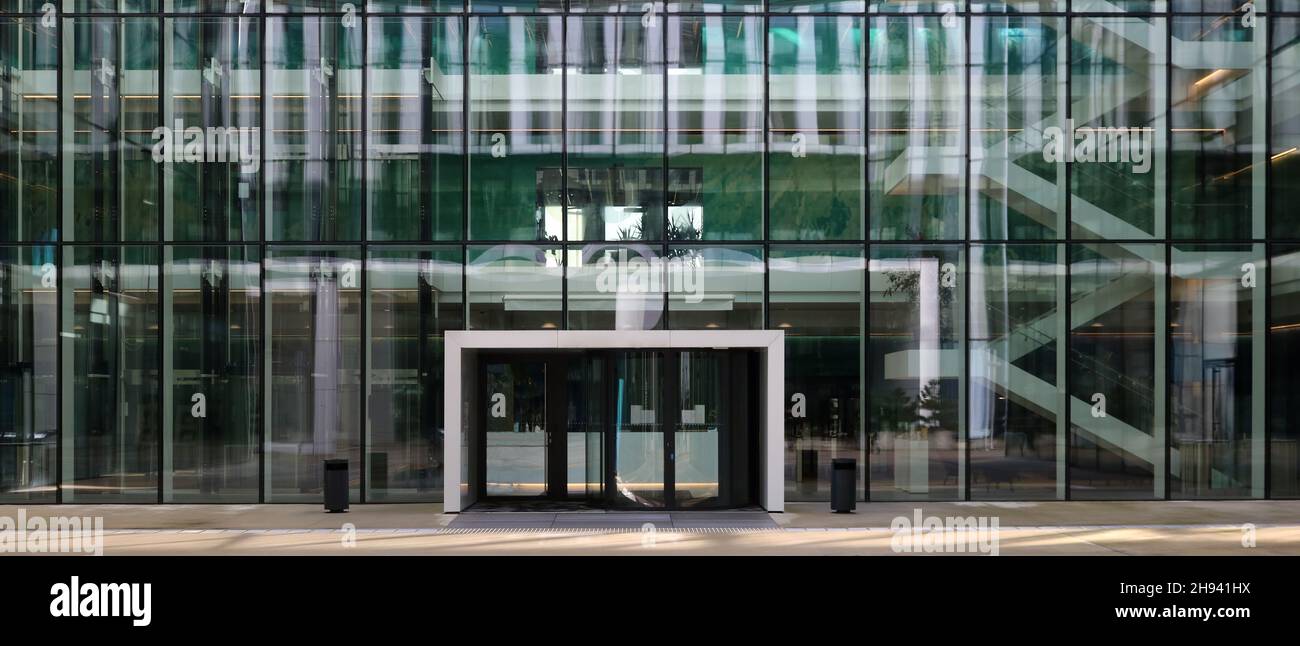 Ventanas de vidrio, puertas y entrada de un moderno edificio de oficinas vacío Foto de stock