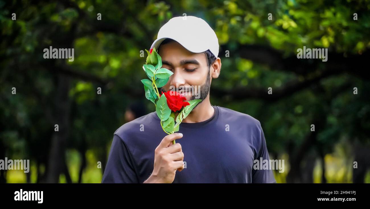 ¿quieres proponer al hombre con hermosa rosa roja en el pensamiento amante imágenes Foto de stock