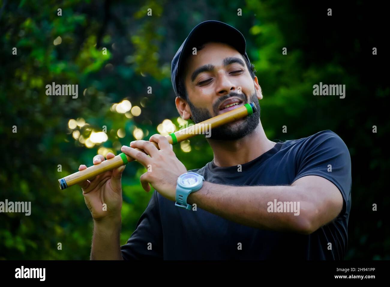 hombre tocando la flauta en un hermoso fondo Foto de stock