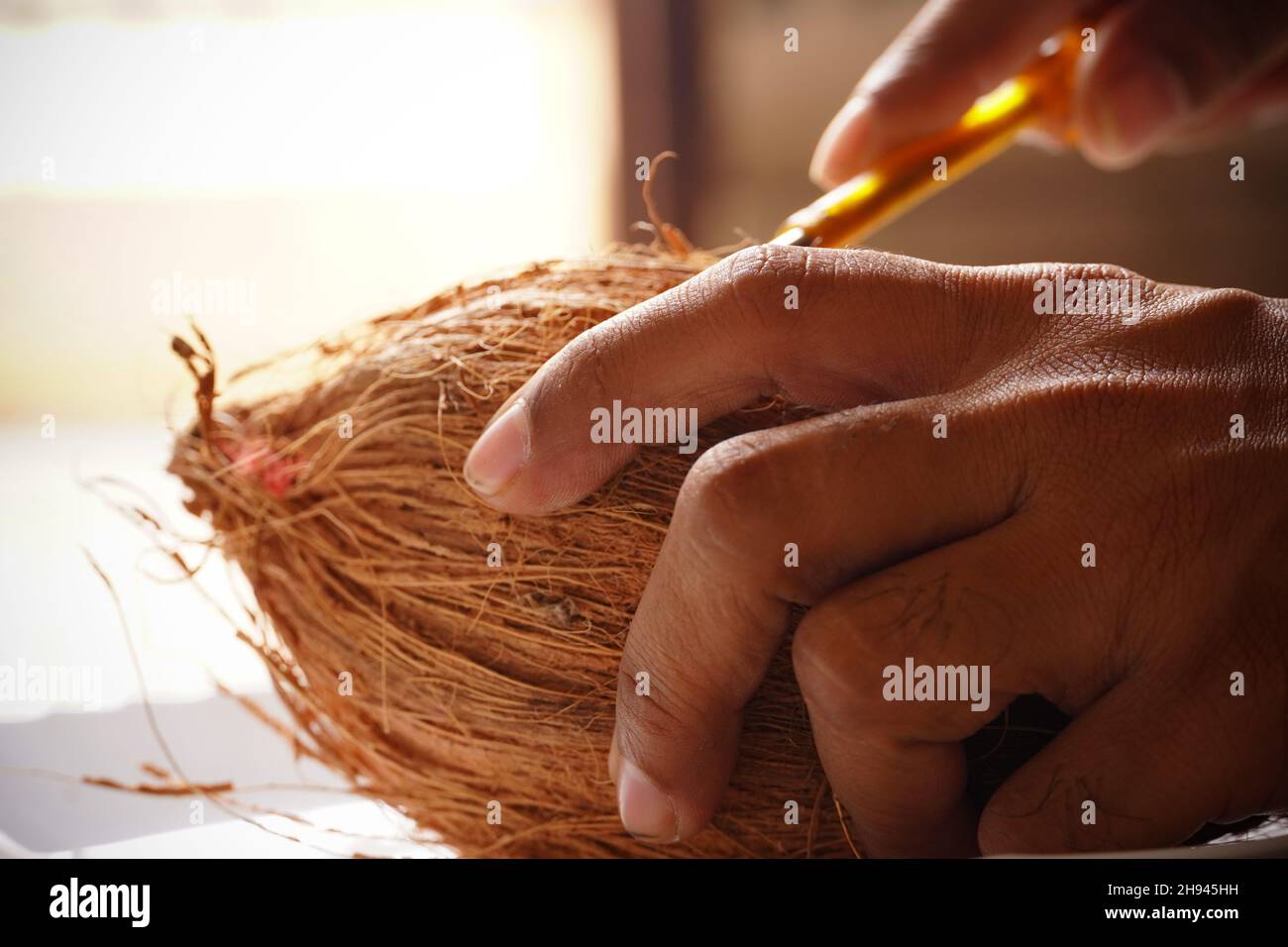 hombre peeling coco de la mano imagen de interior disparar Foto de stock
