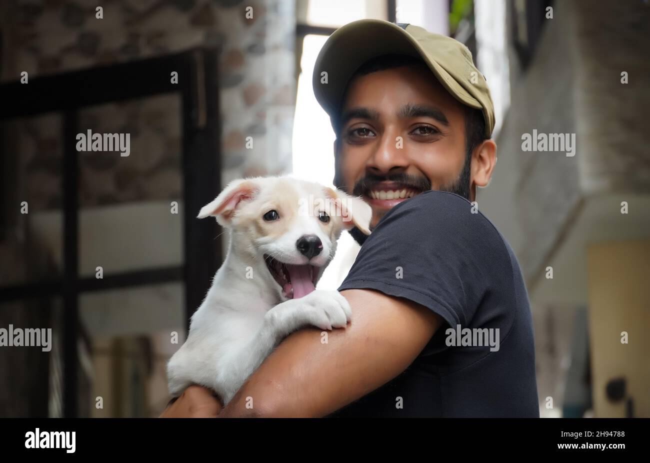 un joven amante del perro con su perro feliz y sonriente Foto de stock