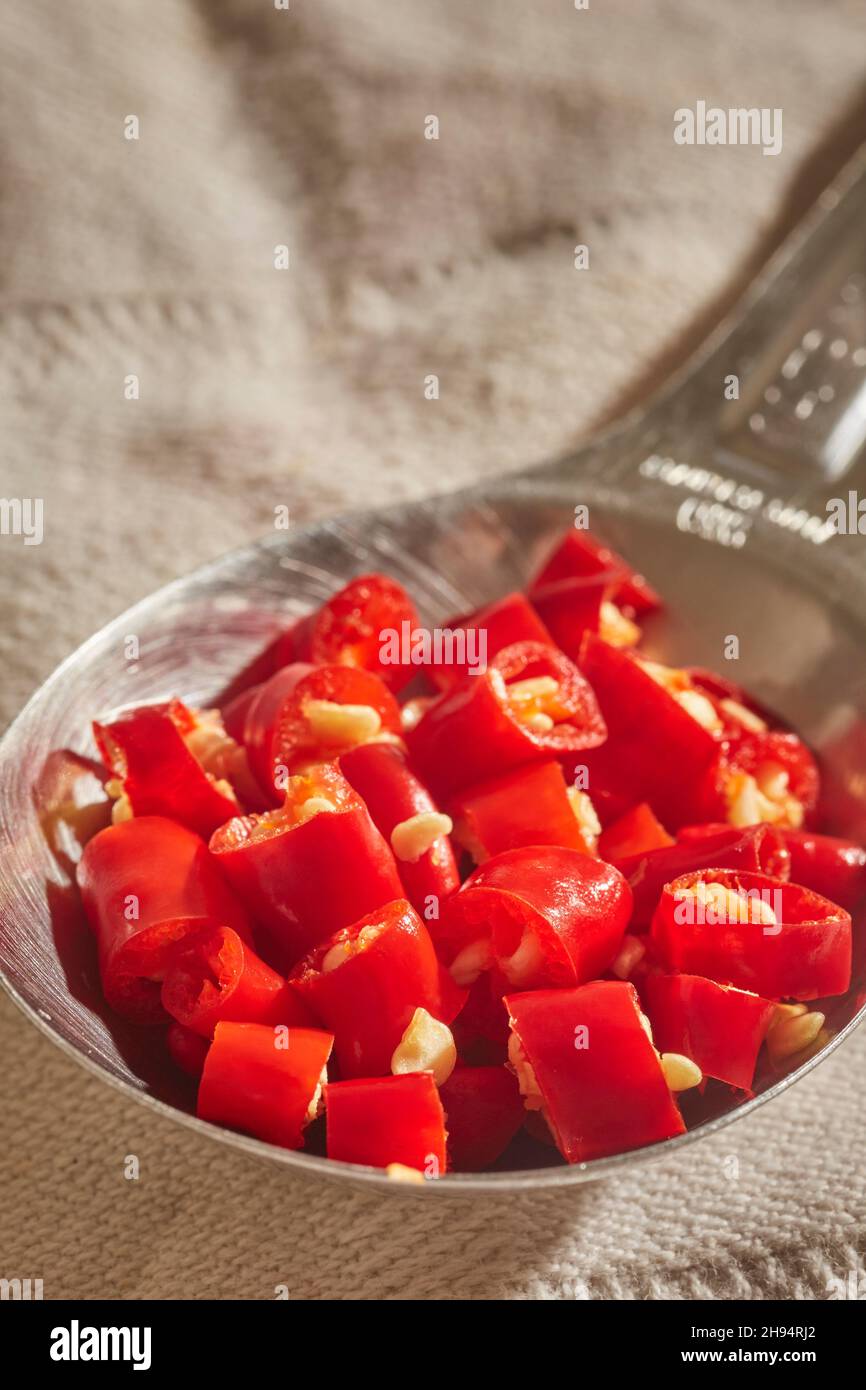 Una cucharada de chiles rojos tailandeses picados y frescos Foto de stock