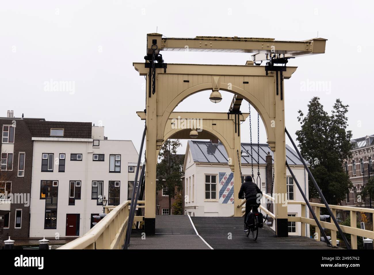 Un ciclista cruza Rembrandtbrug (puente de Rembrandt), un puente levadizo sobre las aguas del río Rin en Leiden, Holanda. Foto de stock