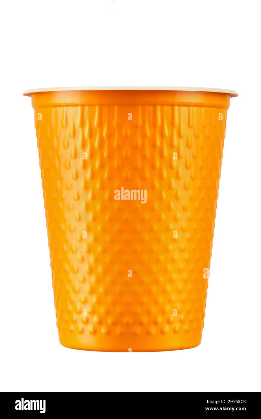 Nuevo vaso de plástico naranja sobre fondo blanco. Vajilla desechable. El archivo contiene la ruta de recorte. Foto de stock