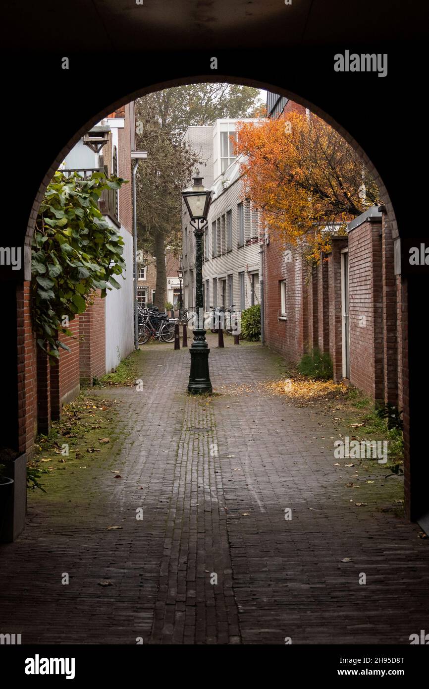 Mirando a través de un pasillo arqueado en Cananefatenpoort en un día de otoño en Leiden, Holanda. Foto de stock
