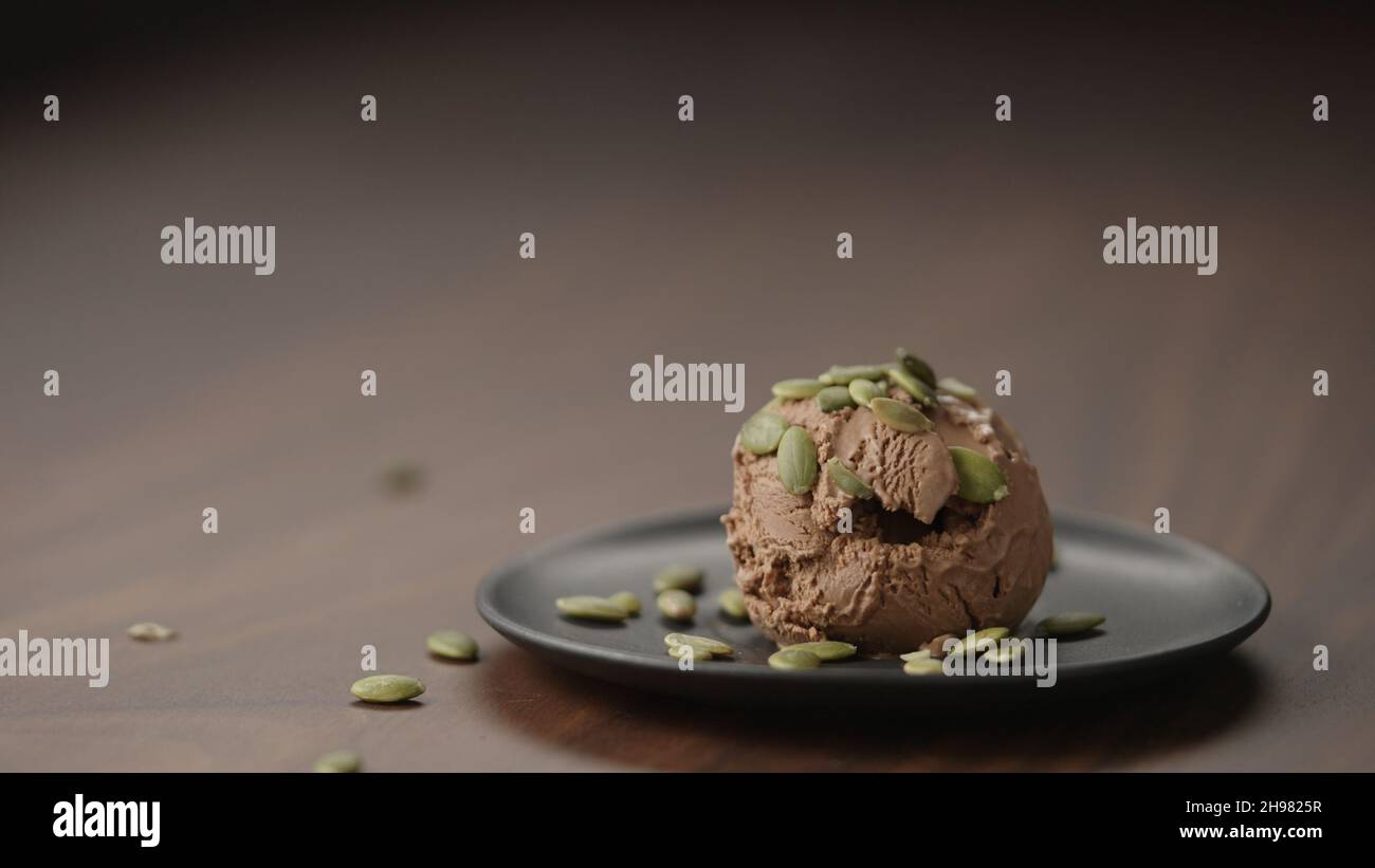 interior Incompatible persona helado de chocolate con semillas de calabaza sobre platillo pequeño sobre  mesa de madera, foto ancha Fotografía de stock - Alamy