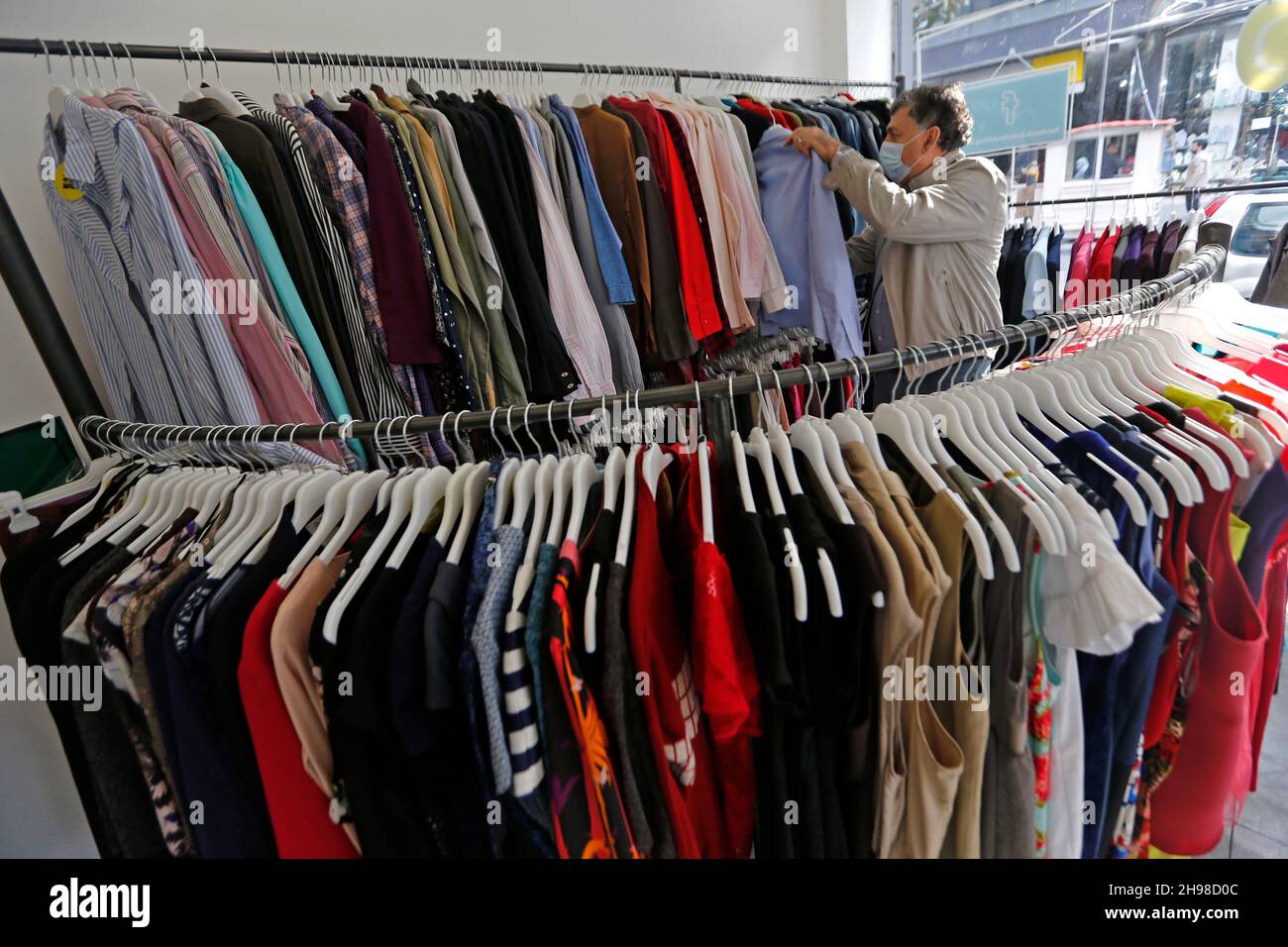 Beirut, Líbano. 3rd de Dic de 2021. Un cliente escoge ropa en una tienda de  ahorro en Beirut, Líbano, 3 de diciembre de 2021. Las tiendas de ahorro,  también conocidas como 'baleh'