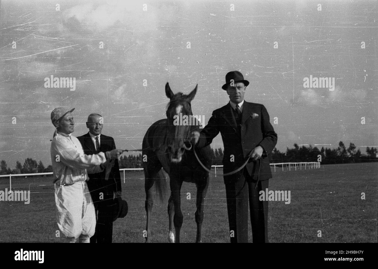 Warszawa, 1947-09-01. Pierwsze powojenne derby na torze wyœcigów konnych na S³u¿ewcu. NZ. zwyciê¿czyni wyœcigu trzyletnia klacz Bystra II OD prawej w³aœciciel stajni R. Kêpski, trener Andrzej Matczak i d¿okej Stefan Michalczyk. ka PAP Varsovia, 1 de septiembre de 1947. El primer Derby de posguerra en el hipódromo de Sluzewiec. En la foto: Ganador de la carrera de tres años mare Bystra II Del propietario estable derecho R. Kepski, el entrenador Andrzej Matczak y el jinete Stefan Michalczyk. ka PAP Foto de stock