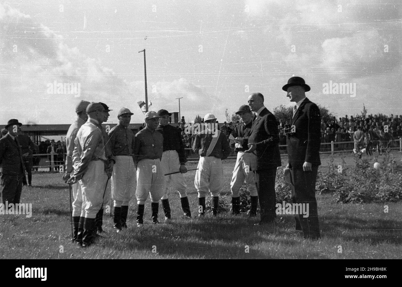 Warszawa, 1947-09-01. Pierwsze powojenne derby na torze wyœcigów konnych na S³u¿ewcu. NZ. D¿okeje na odprawie przed startem. ka PAP Varsovia, 1 de septiembre de 1947. El primer Derby después de la guerra en el hipódromo de Sluzewiec. En la foto: Jinetes durante una reunión antes del inicio. ka PAP Foto de stock