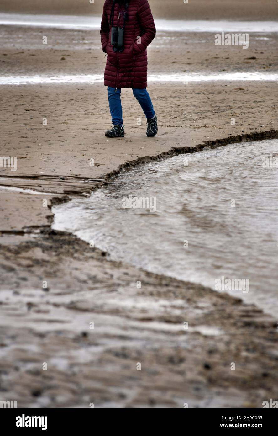 persona solidaria caminando por la playa holme-net-the-sea norfolk england Foto de stock