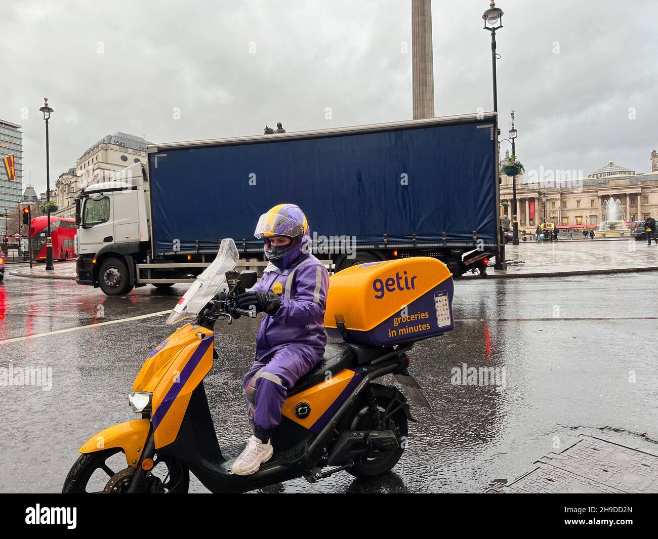 Londres, Reino Unido. 06th de Dic de 2021. Un conductor del servicio de  entrega de Getir se sienta en su scooter cerca de Trafalgar Square en  Londres el 6 de diciembre de