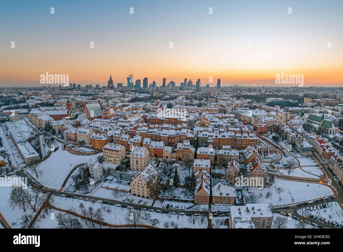 Ciudad vieja de Varsovia, techos cubiertos de nieve y el centro de la ciudad distante al atardecer, panorama aéreo de invierno Foto de stock