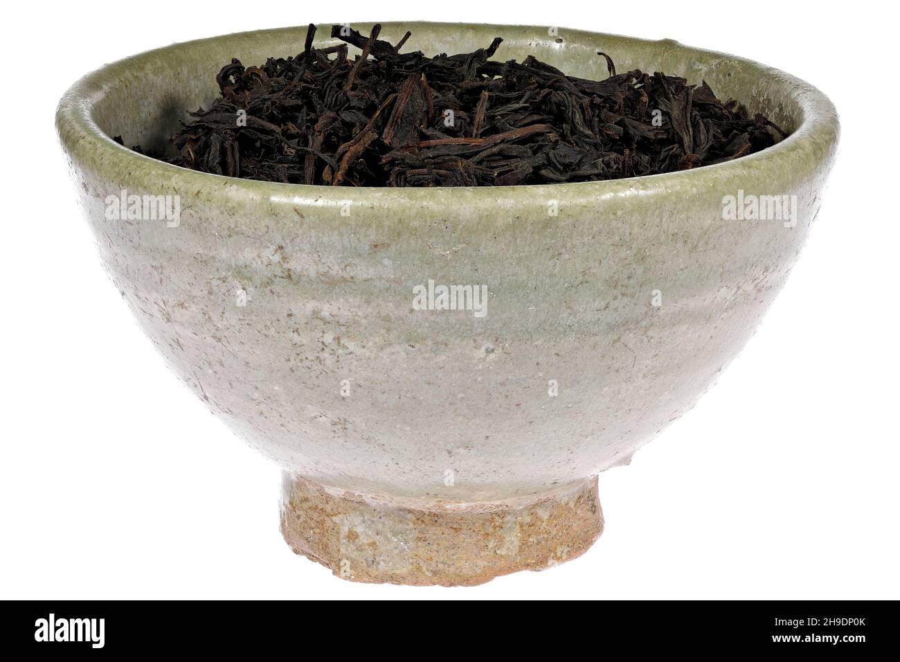 Té negro Ceilán en una vasija de barro de época aislada sobre fondo blanco Foto de stock