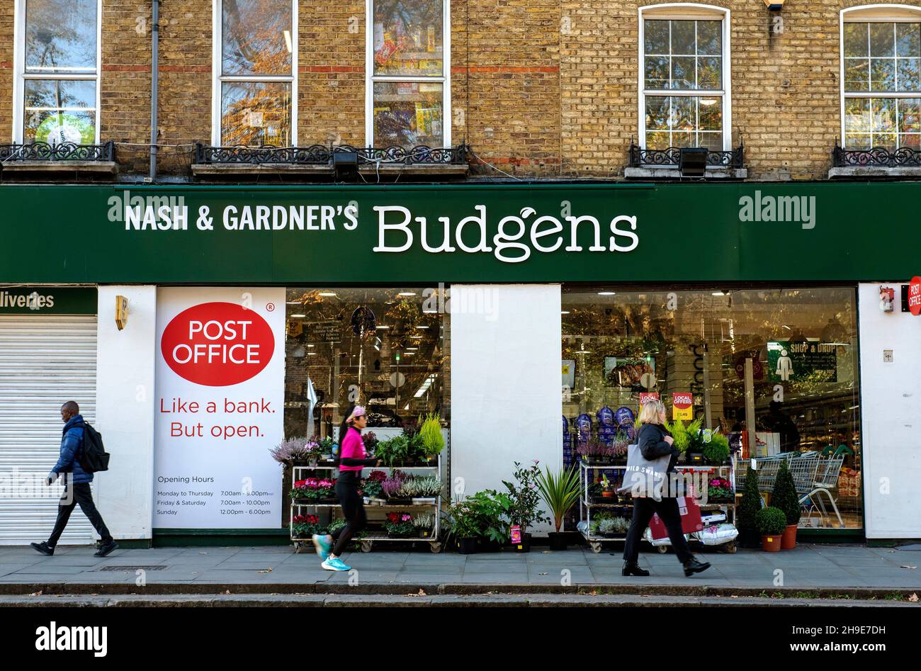 Nash y Gardener's Budgens supermercado tienda con oficina de correos con la gente pasando Upper Street London Borough of Islington Foto de stock
