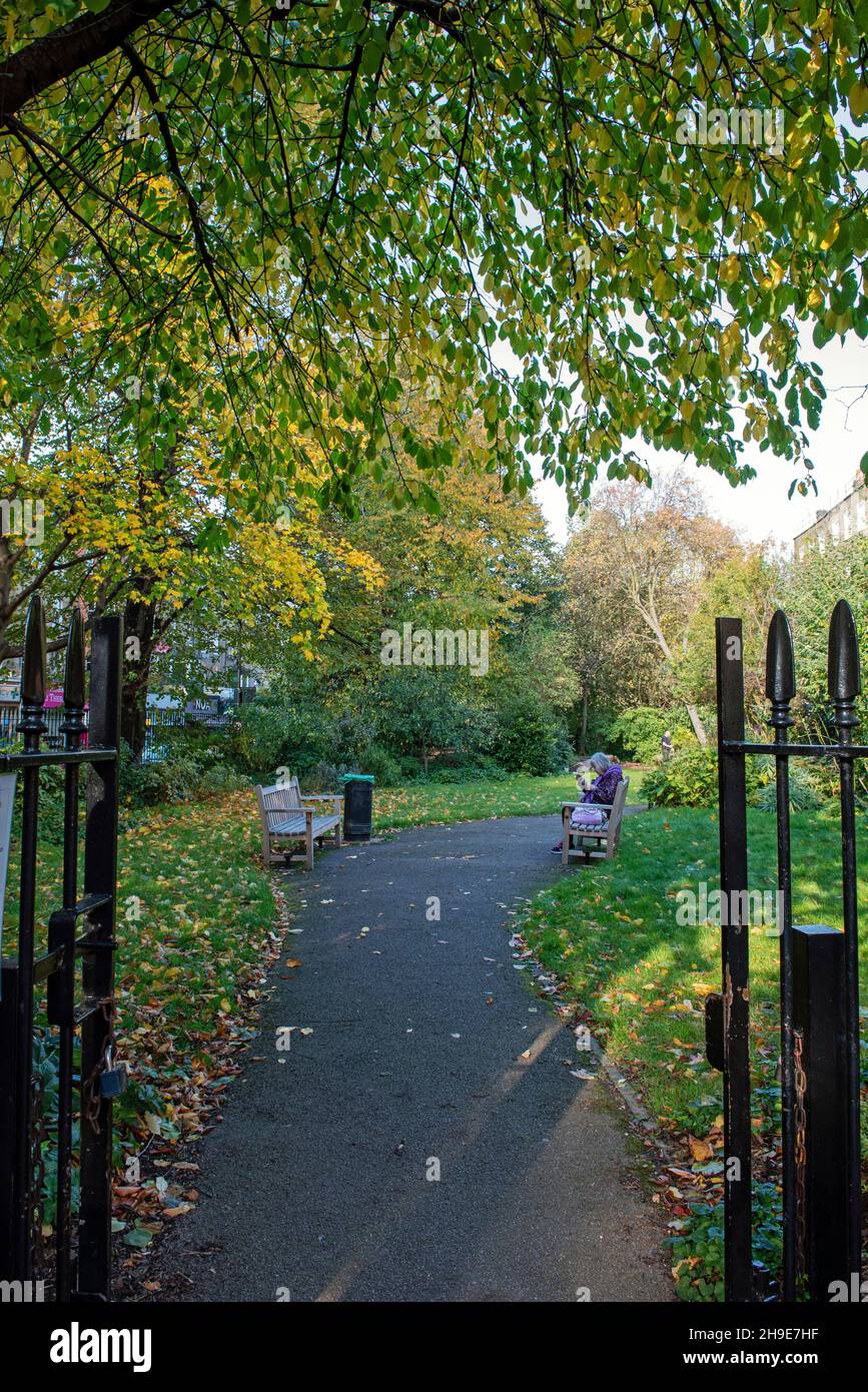 Vista a través de las puertas de entrada de Compton Terrace Gardens, el distrito londinense de Islington Foto de stock