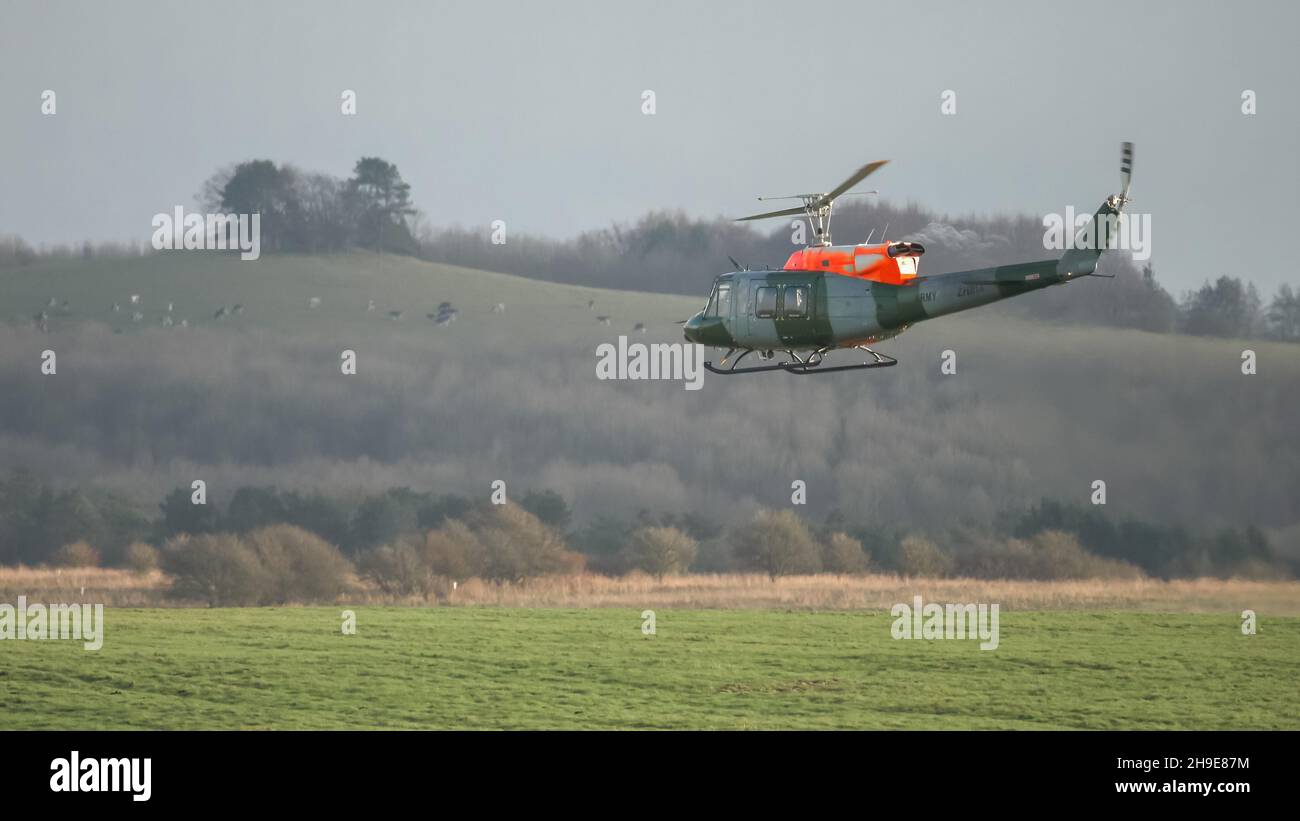 Ejército Británico Cuerpo Aéreo ZJ969 Bell 212 helicóptero que conduce entrenamiento piloto y evaluación, cielo nuboso claro Foto de stock