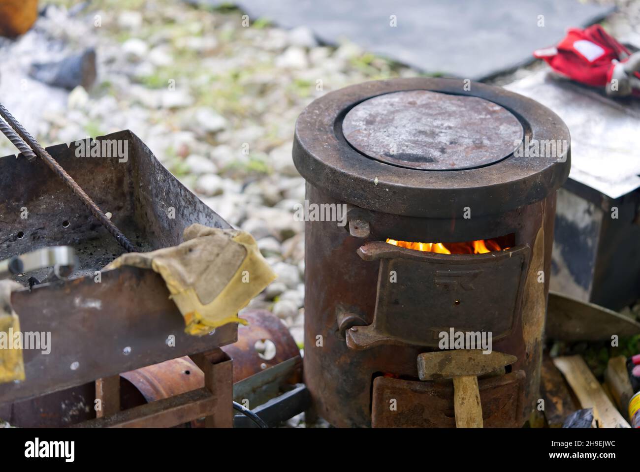 Cocinar en la naturaleza mientras pesca. Estufa de madera vieja y caldero. Cocinar en una chimenea. Picnic en la caza Foto de stock