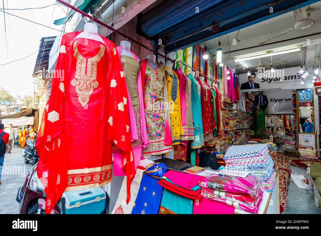 Tienda de venta de ropa y telas locales de colores en Pragpur, un pueblo del patrimonio en el distrito de Kagra, Himachal Pradesh, India Foto de stock