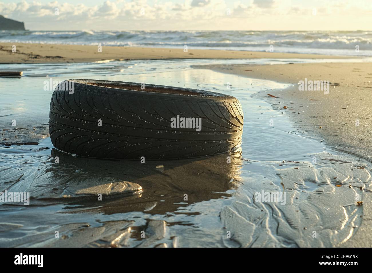Neumático de caucho usado para automóviles desechado en el ecosistema del mar, contaminación ambiental de la naturaleza Foto de stock