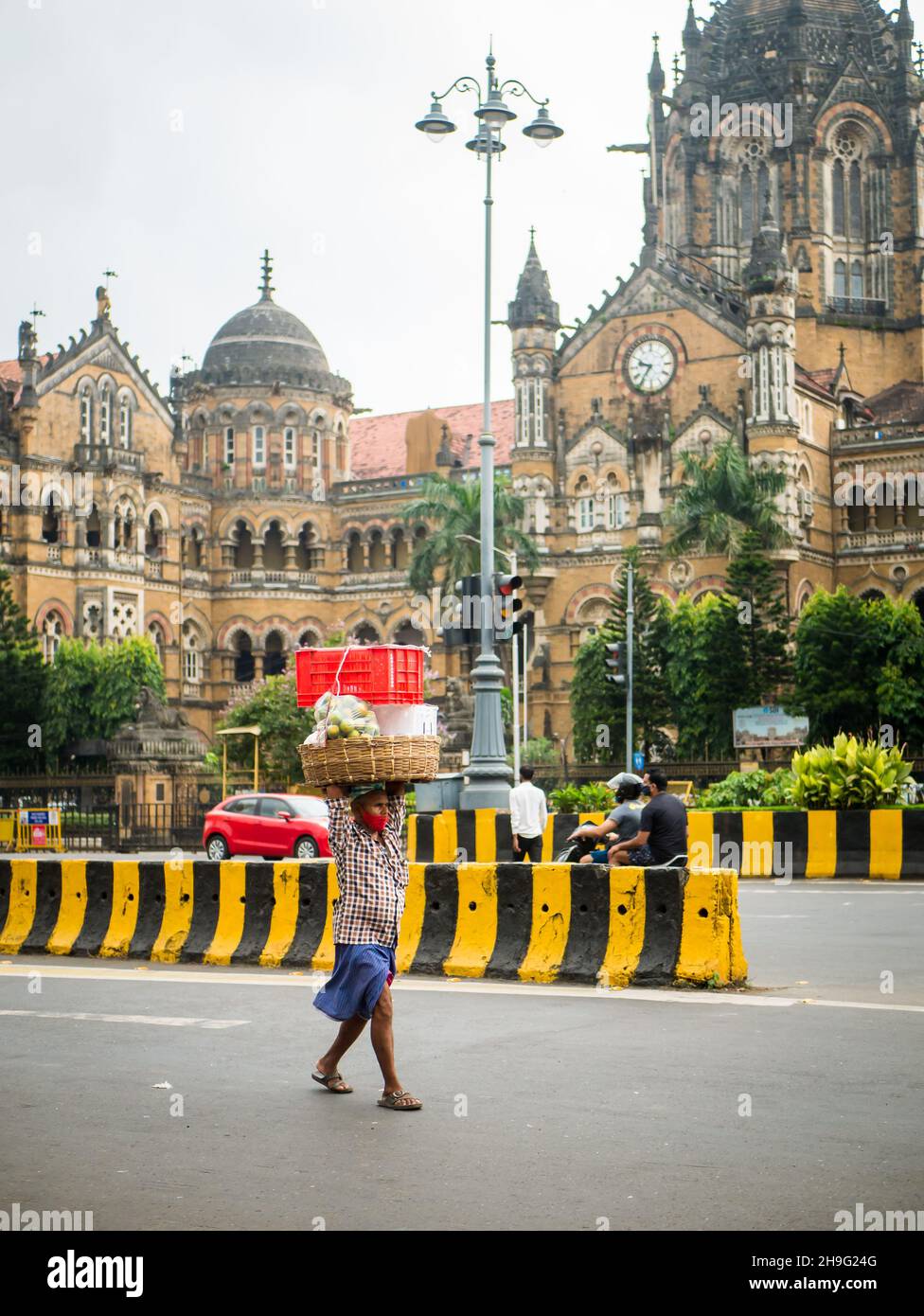 MUMBAI, INDIA - 2 de octubre de 2021 : Portero no identificado que usa una máscara covid-19 que transporta el carro de frutas en la estación CST, Mumbai Foto de stock