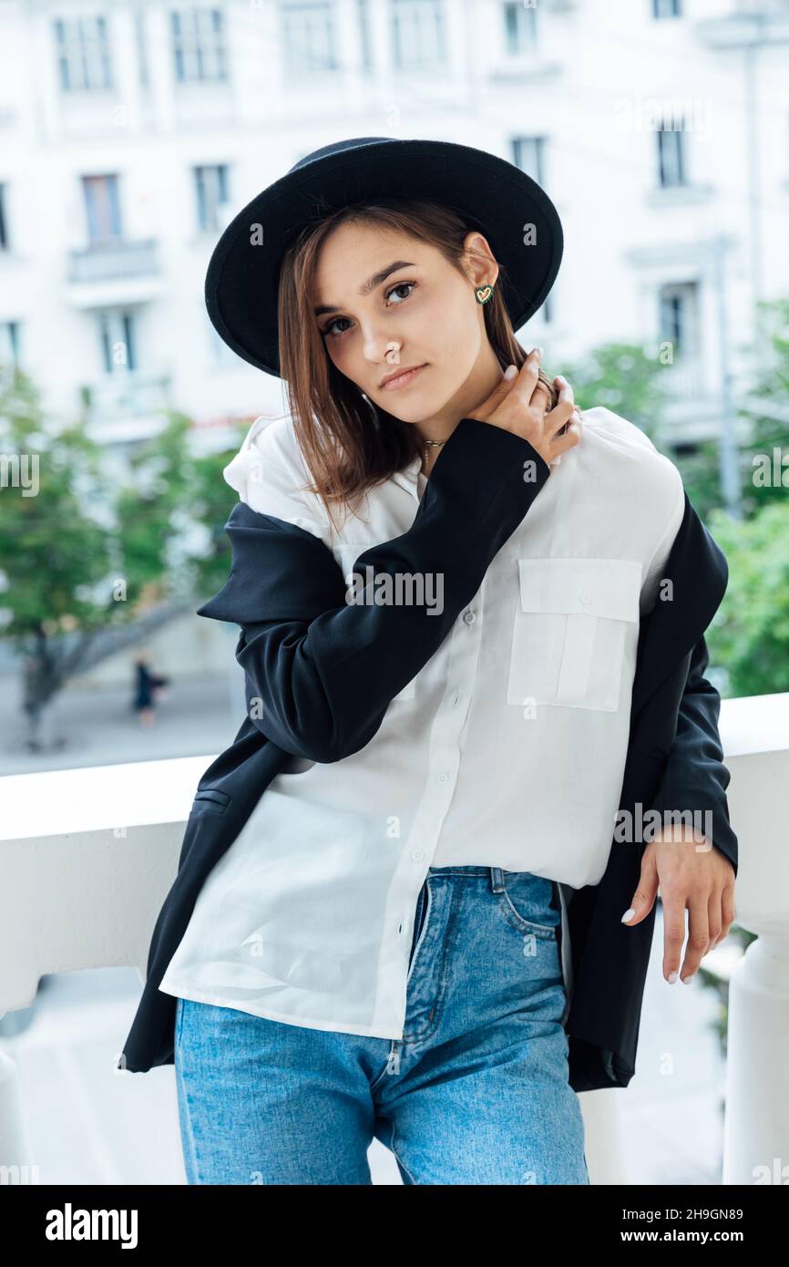 retrato de una hermosa mujer joven de moda en jeans y un sombrero negro  Fotografía de stock - Alamy