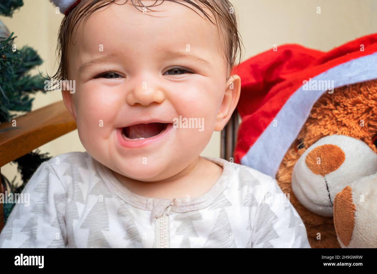 el bebé sonríe y los primeros dientes sobresalen. Navidad Foto de stock