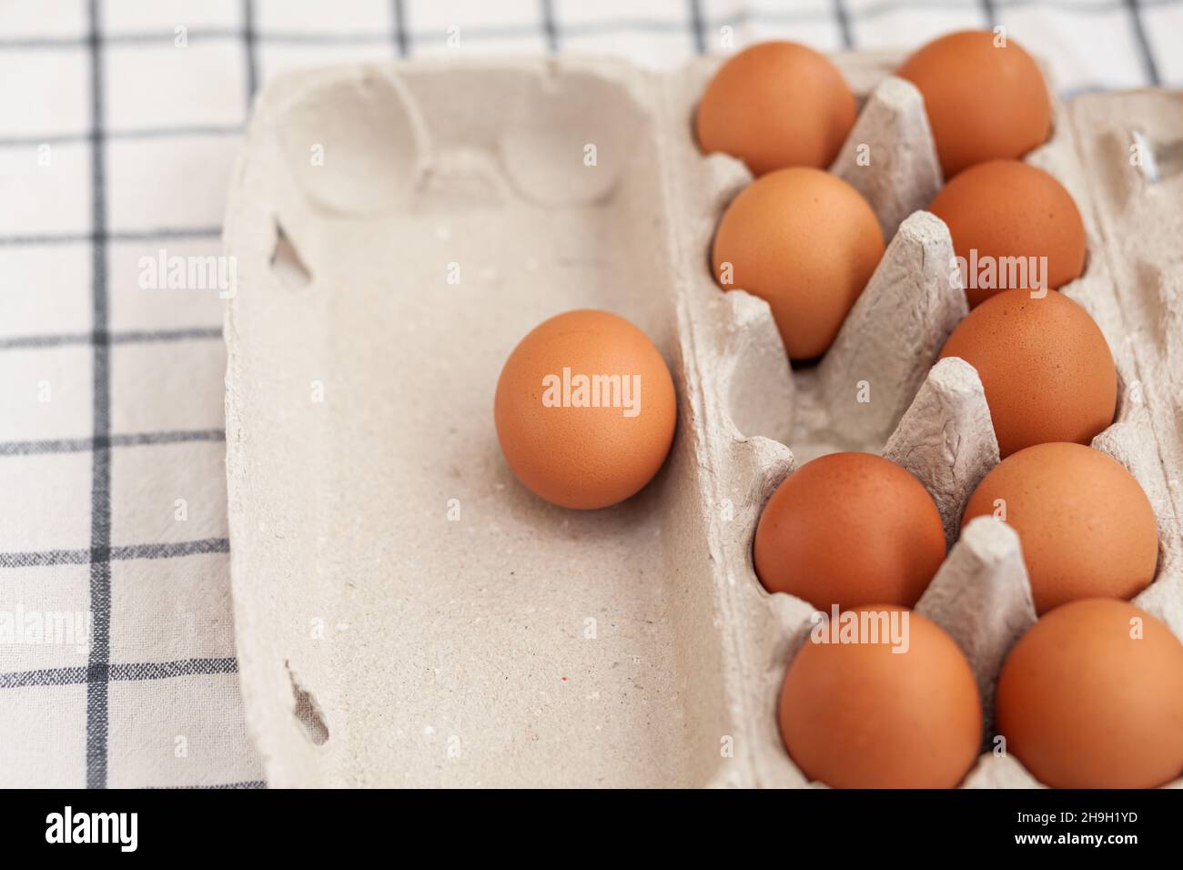 Unos huevos marrones entre las células de una bolsa grande de cartón, un  huevo de pollo como un producto nutritivo valioso, una bandeja para llevar  y almacenar huevos frágiles Fotografía de stock -