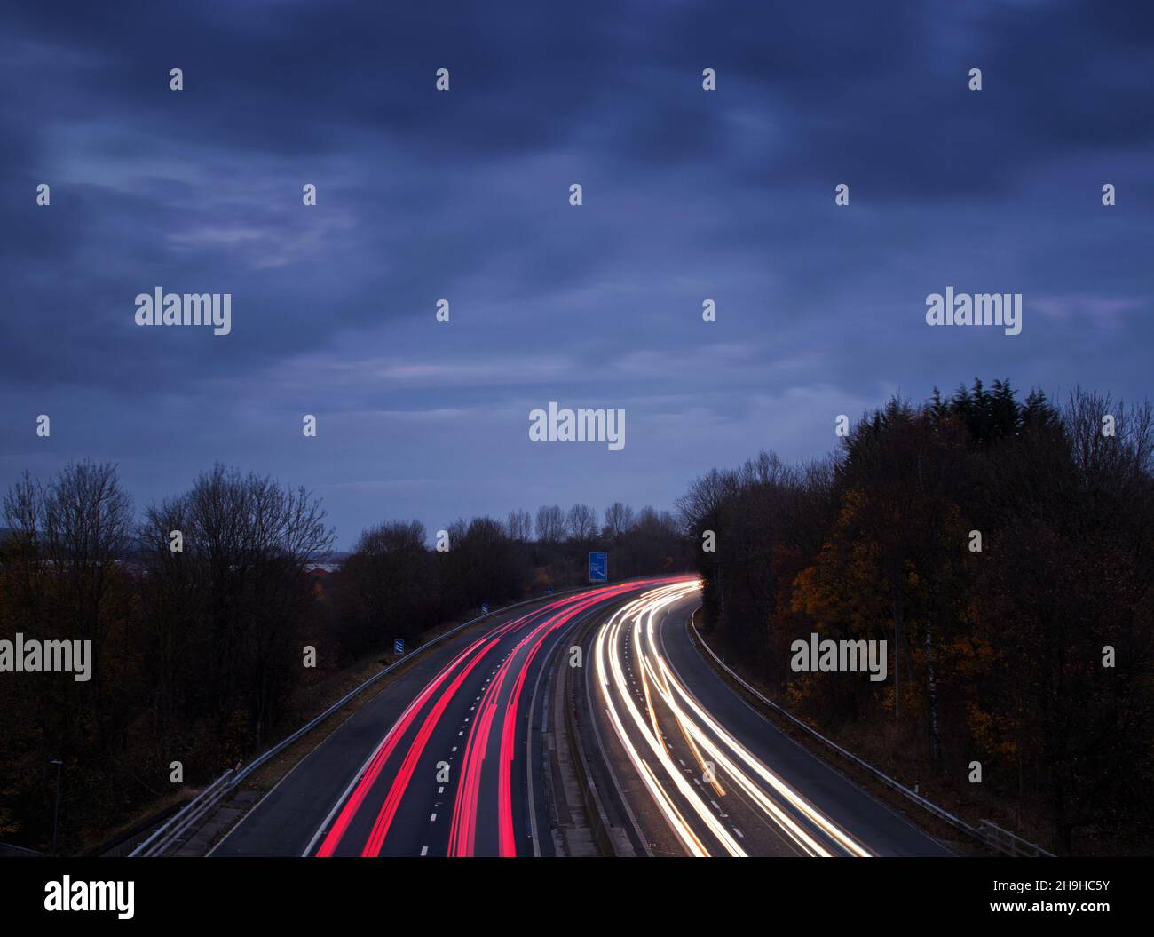 Senderos de luz que ilustran el concepto de conducir a casa al atardecer Foto de stock